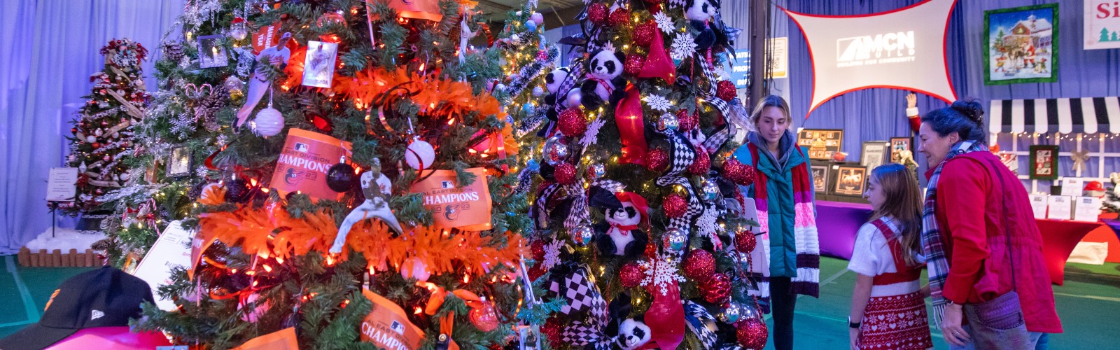 Attendees looking at decorated holiday trees