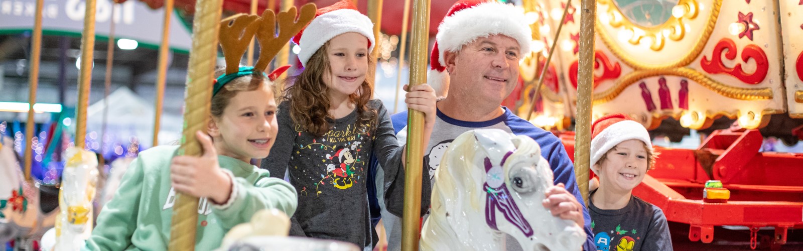 A family on the carousel ride at Festival of Trees