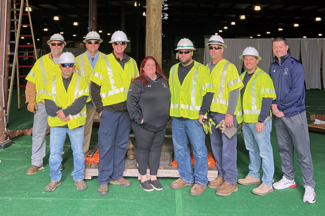 A group of workers from BGE help pose for a photo as they up a display at Festival of Trees.