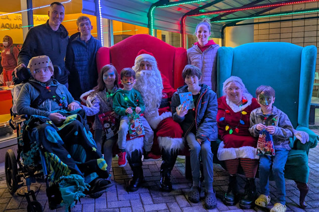 Seamus and his family with Santa Claus and Mrs. Claus. The photo was taken outside Kennedy Krieger during a holiday event.