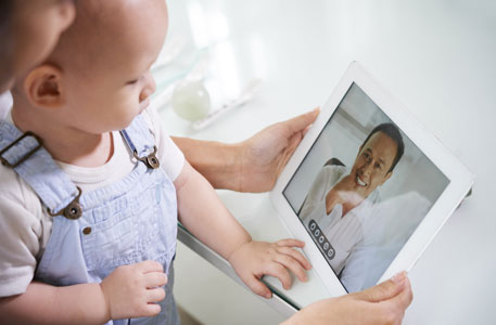 A mother and her baby meet with a doctor on a telehealth call.