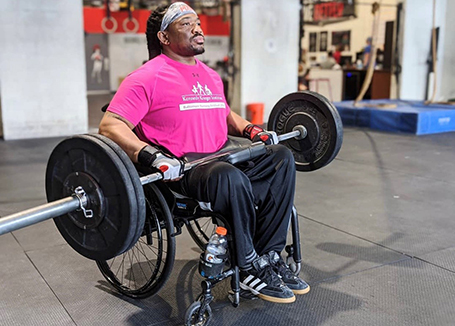 A man weightlifting in a wheelchair.