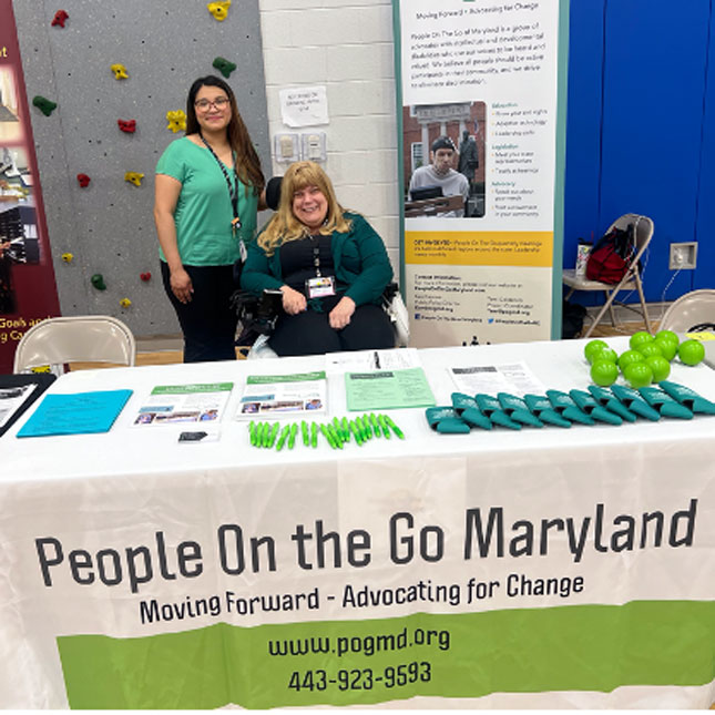 Cindy Ibarra and Tracy Wright behind the People on the Go Maryland exhibitor table at the  Claremont High School Transition Fair. 
