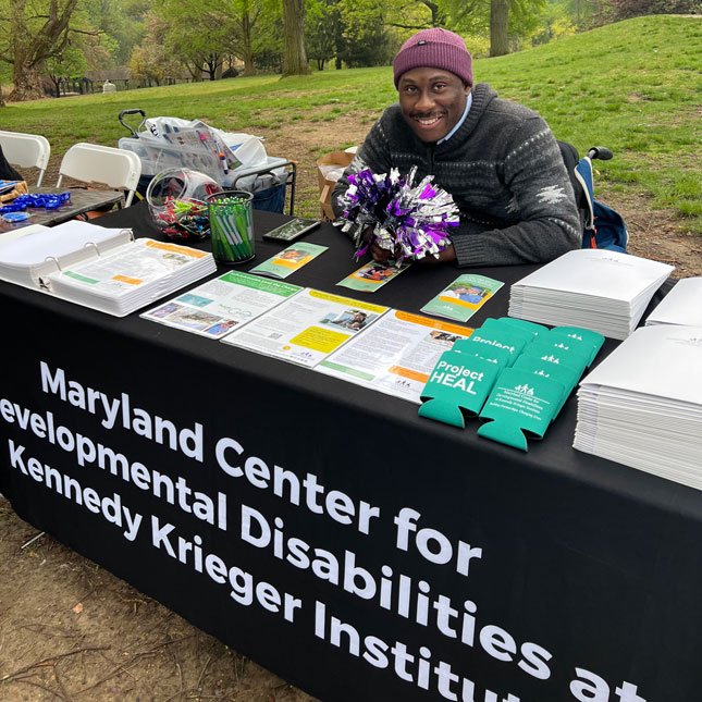 Christopher Mason-Hale behind a Maryland Center for Developmental Disabilities exhibitor table at ROAR for Kids.