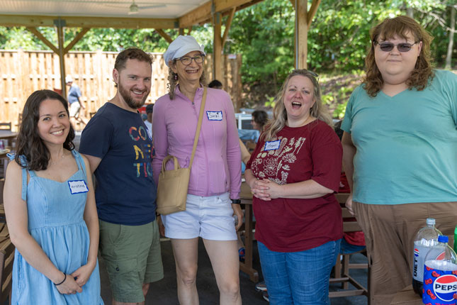 Five people stand for a photo and smile at the AOG picnic.