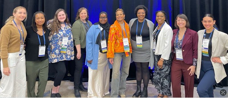 10 people stand next to each other and smile at the AUCD Trainee-Professional Networking Breakfast. 