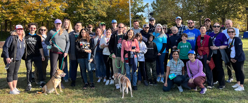 A large group of people stand in the park for a photo at the Out of the Darkness Walk