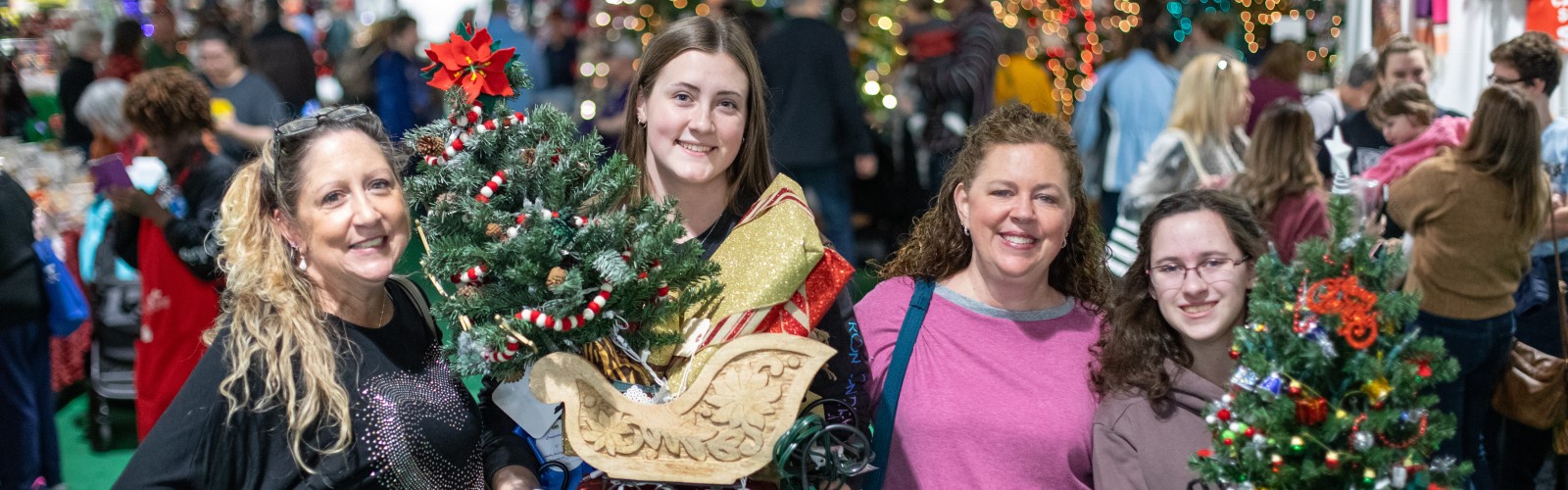 Festival of Trees attendees with small trees in hand