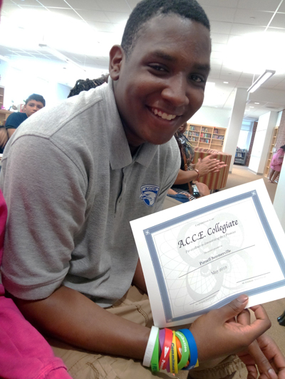 A photo of Purnell holding an A.C.C.E. Collegiate certificate