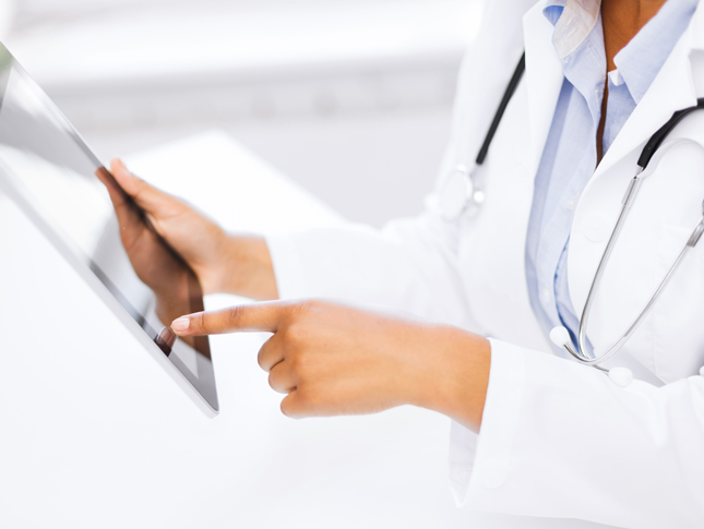 A doctor looks at information on an electronic tablet.