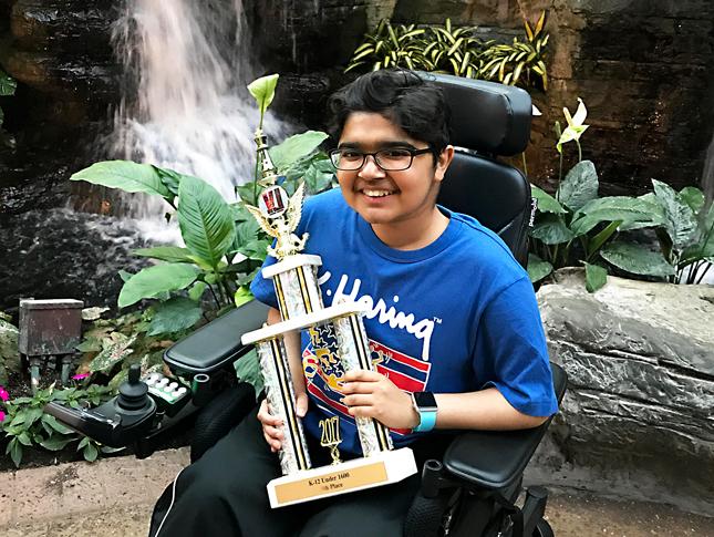 A photo of Kennedy Krieger patient Yuva holding a trophy