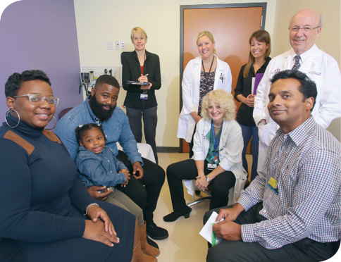 A photo of Journee with her parents, Ebony and Antwonn, and medical team members (left to right, back to front) Dr. Hilary Gwynn, Colleen Lenz, Dr. Sarah Korth, Dr. Shenandoah Robinson, Dr. Frank Pidcock and Dr. Ranjit Varghese.