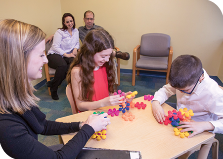 Dr. O’Donnell leads Reagan and Thomas in a creative activity during a therapy session, while Amanda and Todd look on.