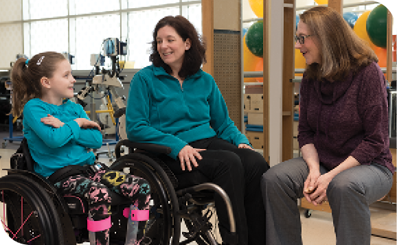 Pediatric nurse practitioner Janet Dean (right) talks with Caetlyn and her mom, Caryn, both patients at the Institute’s International Center for Spinal Cord Injury.