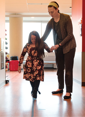 Shannon practices walking on a straight line with physical therapist Marianna Kogut.
