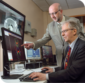 Dr. James Pekar (standing) and Dr. Peter van Zijl watch a brain scan in process.