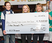 Ann Moser with Taylor Kane, and her mom, Diane Kane, as they present a check for ALD research