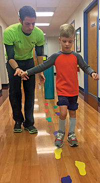 At Kennedy Krieger’s outpatient center, Nathaniel practices walking with physical therapist Jason Benincasa.
