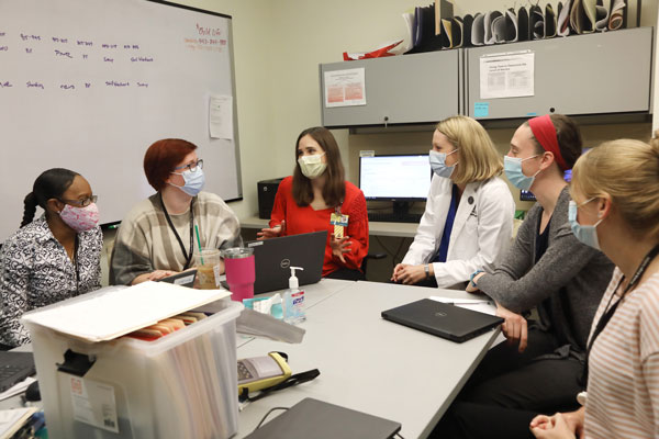 Clinic team members meet to discuss their recommendations for each patient at the end of each clinic session.