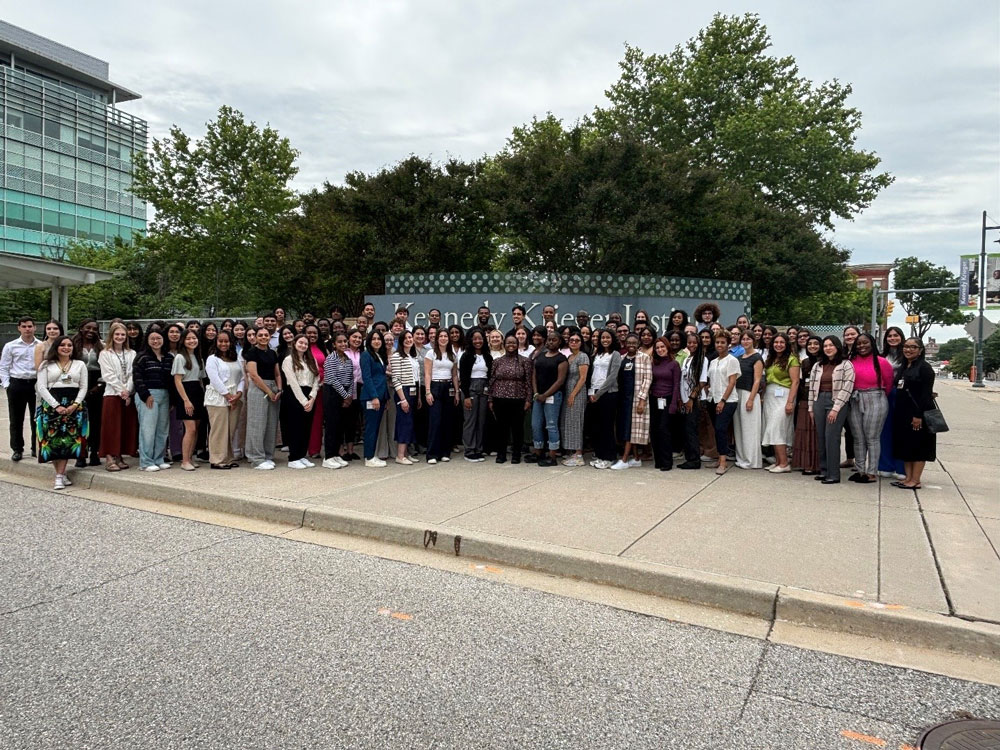 A large group of Center for Diversity scholars gather for a group photo outside of Kennedy Krieger Institute.