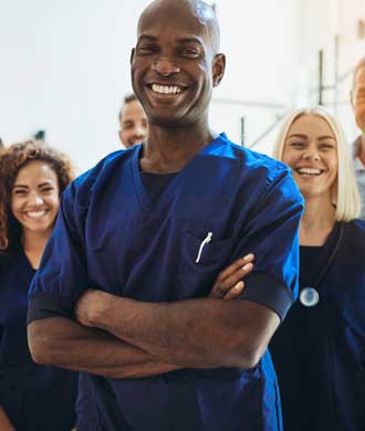 A team of doctors and nurses stand for a photo. 