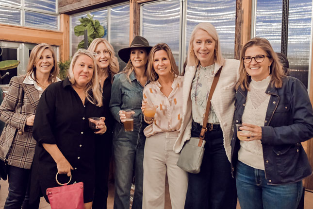 Seven women stand for a photo and smile at Barrels & Bonfires 2023.