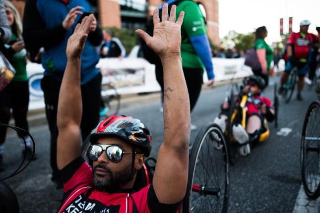 Handcyclists cross the finish line.