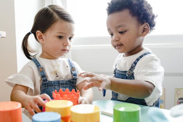 Two children play in an early childhood learning center classroom. 