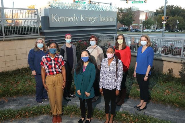 فريق عيادة إعادة تأهيل الأطفال عقب فيروس كوفيد-19 يقف في الحديقة العلاجية لمعهد Kennedy Krieger من أجل التقاط صورة.