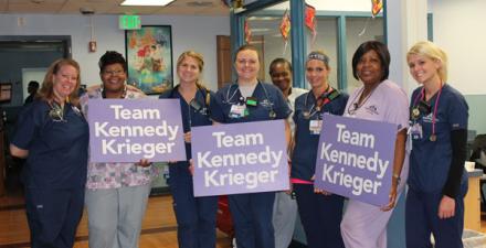 A group of nurses standing in a row. Some are holding Team Kennedy Krieger signs.
