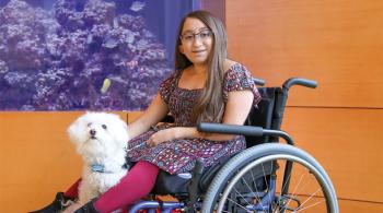 Frosty, Shannon's service dog, keeps Shannon safe when she's walking in public. Frosty makes sure no one bumps into Shannon, which could harm Shannon's bones. For longer distances, Shannon uses a wheelchair, with Frosty curled up in her lap or at her feet. In this picture, Shannon is sitting in her wheelchair, with Frosty sitting by her feet.