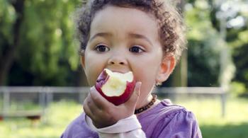 A young child eating an apple.