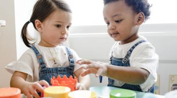 Two children play in an early childhood learning center classroom. 