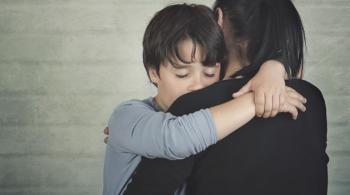 Un niño triste consolado por su madre.