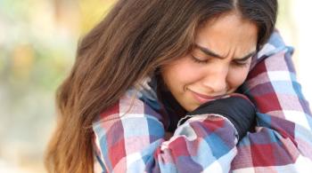 A teenaged girl worried and sad, crying outdoors.