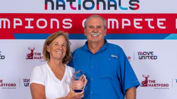 Gwena Herman stands next to her husband Gerry while holding the Jan Elix Award.